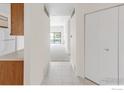 Hallway with white tile flooring leading to carpeted living area at 3260 47Th St # 207A, Boulder, CO 80301