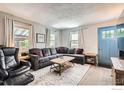 Comfortable living room with a gray sectional sofa, natural light, and a view of the outdoors at 4009 W 52Nd Ave, Denver, CO 80212