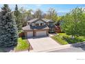Beautiful two-story home with manicured lawn, mature trees, a brick facade and three-car garage at 540 Columbine Ave, Broomfield, CO 80020
