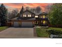 Two-story home with brick facade, three-car garage, and manicured front yard at sunset at 540 Columbine Ave, Broomfield, CO 80020