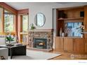 Inviting living room with a stone fireplace, built-in shelving, and natural light from large windows at 560 Northstar Ct, Boulder, CO 80304