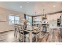 Dining area next to a modern kitchen, features an elegant dining table and seamless access to the outdoor space at 6732 E 119Th Ave, Thornton, CO 80233