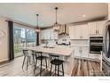 Modern kitchen with stainless steel appliances, white cabinets, large island, and access to the backyard at 6732 E 119Th Ave, Thornton, CO 80233