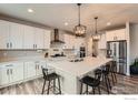 Spacious kitchen features a large island, stainless steel appliances, stylish lighting, and sleek white cabinetry at 6732 E 119Th Ave, Thornton, CO 80233