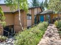 Inviting home exterior featuring a vibrant blue front door, lush landscaping, and a stone pathway to the entrance at 700 Poplar Ave, Boulder, CO 80304
