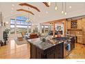 Bright living room with wood beams, hardwood floors, a fireplace, and large windows showcasing the mountain view at 750 Left Fork Rd, Boulder, CO 80302
