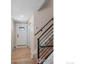 Inviting entryway featuring wood-look floors, a white door with glass and stairs with black railings at 8334 Allison Ct, Arvada, CO 80005