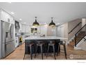 Spacious kitchen featuring a large center island, stainless steel appliances, and modern lighting at 8334 Allison Ct, Arvada, CO 80005