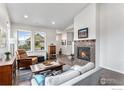 Bright living room with hardwood floors, a modern fireplace, and large windows showcasing the neighborhood at 860 Widgeon Dr, Longmont, CO 80503