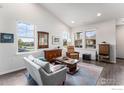 Open-concept living space featuring tall ceilings, hardwood floors, and plenty of natural light from large windows at 860 Widgeon Dr, Longmont, CO 80503