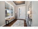 Bright foyer with hardwood floors, a bench, and a decorative mirror at 916 Rocky Ridge Cir, Erie, CO 80516
