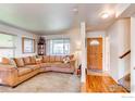 Cozy living room featuring a comfortable sectional sofa, large windows, and natural light at 11656 Logan St, Northglenn, CO 80233