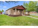Charming single-story brick home featuring a well-maintained front yard on a corner lot at 120 E Nebraska Ave, Berthoud, CO 80513