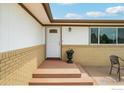 Inviting home entrance with brick accents and a beautiful flower arrangement in front of the door at 12734 Anhawa Ave, Longmont, CO 80503