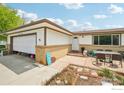 Charming home exterior with a two-car garage, brick accents, and a well-manicured lawn at 12734 Anhawa Ave, Longmont, CO 80503