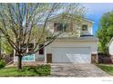 Charming two-story home features a well-manicured front yard and a two-car garage at 1295 Cumberland Dr, Longmont, CO 80504