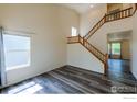 Inviting open floor plan with elegant staircase and large bright window at 1295 Cumberland Dr, Longmont, CO 80504