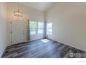 Bright living room featuring high vaulted ceilings and three large windows at 1295 Cumberland Dr, Longmont, CO 80504