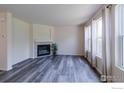 Bright living room featuring a cozy fireplace, modern flooring, and large windows for ample natural light at 1295 Cumberland Dr, Longmont, CO 80504