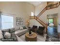 Bright living room featuring vaulted ceilings, stylish furniture, and a staircase at 1295 Cumberland Dr, Longmont, CO 80504