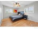Bright bedroom featuring hardwood floors, contemporary decor, and two windows at 13455 W 21St Pl, Golden, CO 80401