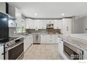 Modern kitchen with white cabinets, granite countertops, stainless steel appliances, and tile floors at 13455 W 21St Pl, Golden, CO 80401