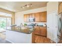 Bright kitchen featuring wood cabinets, stainless steel appliances, a large island, and hardwood floors at 1404 Tonkin Pl, Longmont, CO 80504
