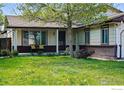 Inviting home featuring a covered front porch, well-manicured lawn, and charming curb appeal at 1839 Stratford Ln, Longmont, CO 80503