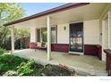Inviting covered front porch with bench seating, perfect for enjoying the outdoors at 1839 Stratford Ln, Longmont, CO 80503