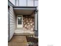 Inviting entrance with stone accents and neutral siding at 2002 E 102Nd Cir, Thornton, CO 80229