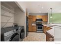 Well-equipped kitchen with stainless steel appliances and adjacent laundry area at 2002 E 102Nd Cir, Thornton, CO 80229