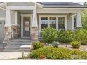 Inviting front porch with stone accents, a small decorative railing, and decorative landscaping at 2026 Braeburn Ct, Longmont, CO 80503