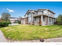 Landscaped front yard showcases this lovely home featuring a two-car garage and a welcoming front porch at 2193 Sand Dollar Cir, Longmont, CO 80503