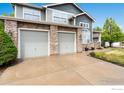 This exterior shot highlights a three-car garage accented with stone and siding, providing ample parking at 2193 Sand Dollar Cir, Longmont, CO 80503