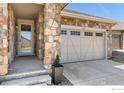 Attractive home showcasing stone accents, a two-car garage, and an inviting entrance, perfect for Gathering living at 2422 E 156Th Pl, Thornton, CO 80602