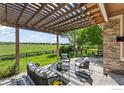 Inviting outdoor patio featuring a pergola, comfortable seating, and a scenic view of the green landscape at 2458 Vale Way, Erie, CO 80516