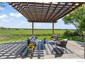 Inviting outdoor patio featuring a pergola, comfortable seating, and a scenic view of the green landscape at 2458 Vale Way, Erie, CO 80516
