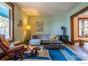 Inviting living room with wood trim, a comfortable couch, accent chair, and hardwood floors at 2645 5Th St, Boulder, CO 80304
