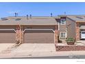 Attractive townhome featuring a two-car garage, brick accents, and a tidy front yard, inviting and well-kept at 2875 W Davies Ave, Littleton, CO 80120