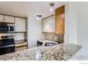 Bright kitchen boasts granite countertops, stainless steel appliances, and stylish tile backsplash at 305 S Taft Ct, Louisville, CO 80027
