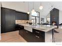 Modern kitchen boasts sleek black cabinets, marble countertops, and stainless steel appliances at 306 S 3Rd Ave, Superior, CO 80027