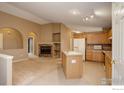 Open concept living room with a fireplace, kitchen island and neutral tones at 3252 Billington Dr, Erie, CO 80516