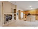 Open concept living room with a stone fireplace, kitchen, and natural lighting at 3252 Billington Dr, Erie, CO 80516