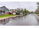 A quiet street view showcasing the neighborhood homes on a rainy day at 3252 Billington Dr, Erie, CO 80516