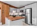 Well-lit kitchen with stainless steel appliances, wood countertop, and white cabinets at 41 Silver Spruce, Boulder, CO 80302
