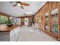 Open-concept space boasting wood-paneled walls, a stone fireplace, hardwood floors, and plenty of natural light at 41 Silver Spruce, Boulder, CO 80302