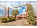 Charming red brick home with stone accents and a rustic wooden entryway, all surrounded by lush greenery at 4963 Kelso Rd, Boulder, CO 80301