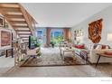 Inviting living area with staircase, view to outside, a tiger wall hanging, and comfortable seating at 6328 E Mississippi Ave, Denver, CO 80224