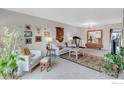 Spacious living room with carpet, white sofas, unique decorations, and a large mirror at 6328 E Mississippi Ave, Denver, CO 80224