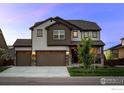 Charming two-story home with a three-car garage, well-maintained lawn, and covered front porch at 647 Boulder Peak Ave, Erie, CO 80516